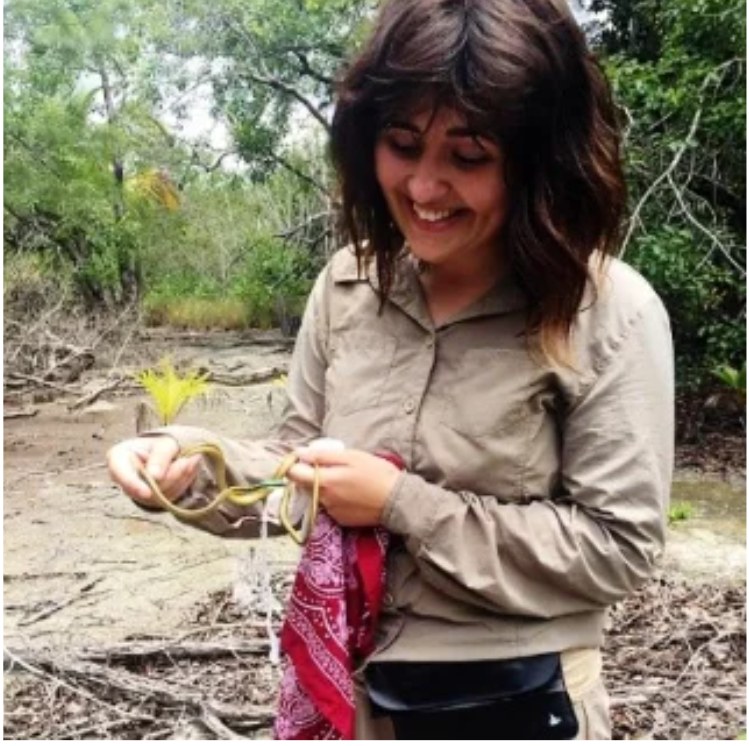Emma holding a snake during fieldwork